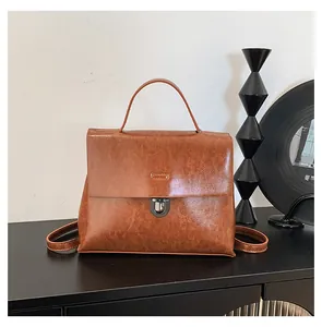 Detailaufnahme des braunen Vintage-Rucksacks mit Ölhaut-Textur und Metallschnalle auf Tisch