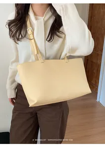 Close-up of creamy yellow PU tote bag texture with adjustable silver metal buckle