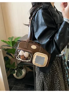 Détail du sac polochon en cuir marron avec fenêtre transparente et ourson en peluche