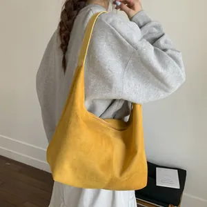 Large yellow suede hobo shoulder bag for women with minimalist aesthetic and wide strap