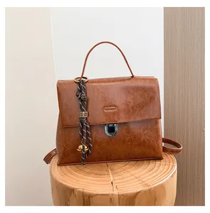 Detailansicht der braunen Ledertextur und Metallschnalle dieser Vintage-Handtasche