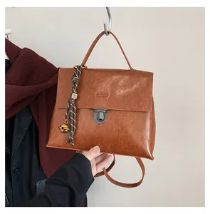 Detailansicht eines braunen Vintage-Rucksacks mit Metallschnalle und gewebtem Seilanhänger