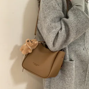 Sac seau rétro marron texture litchi avec breloque ours en peluche et bandoulière
