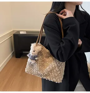 Detailed close-up of a vintage woven tote bag with a cute plush bear charm and brown leather straps