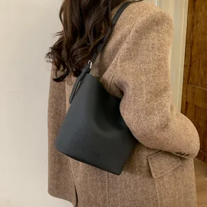Chic black pebbled leather bucket bag styled with a wool blazer for daily commute fashion