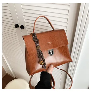 Nahaufnahme der braunen Vintage-Handtasche mit silbernem Drehverschluss und Anhänger