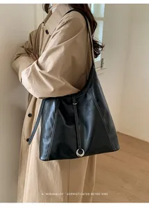 Détail du sac hobo en cuir noir avec surpiqûres blanches contrastées et boucle argentée