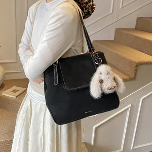 Retro black bucket tote bag with white contrast stitching and a plush rabbit charm