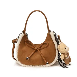 Brown suede crescent bag for women with white faux fur trim and cute teddy bear charm