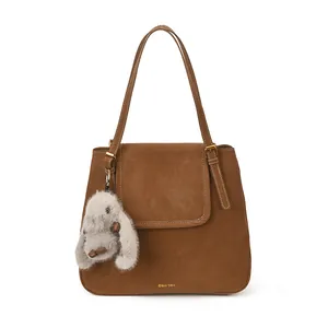 Brown vintage faux leather bucket tote bag with white stitching and plush bunny charm