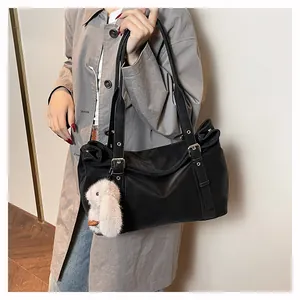 Detail of black nylon tote bag with silver rivets and cute white rabbit plush charm