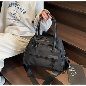 Close-up of durable black nylon fabric texture and reinforced leather handles of the tote bag