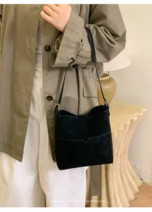 Gros plan détaillé du sac seau noir minimaliste avec poche en V et texture mate