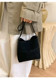 Détail du sac seau noir mat avec poche en V et bandoulière réglable