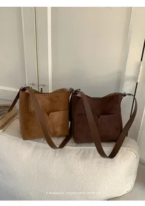 Détail de la texture des sacs seaux rétro en daim synthétique marron et café