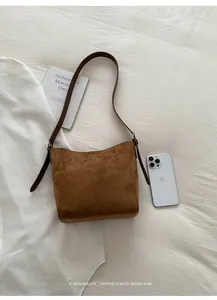 Détail du sac seau en cuir mat marron foncé avec couture en V et boucle en métal argenté