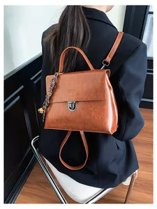 Detail eines braunen Vintage-Lederrucksacks mit silbernem Drehschloss und Seidenschal