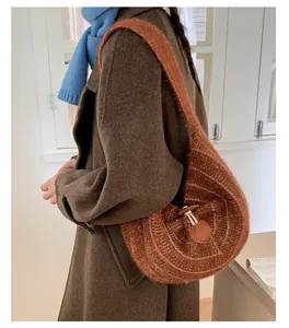 Detail of brown knit hobo bag featuring wood toggle closure and contrast stitching accents