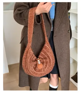 Detail of a brown knitted half-moon bag featuring a vintage toggle button closure