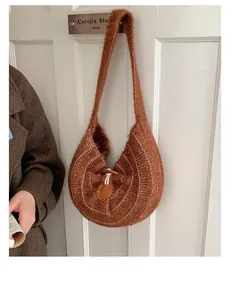 Detail of a brown knitted crescent bag featuring a vintage toggle closure on a door
