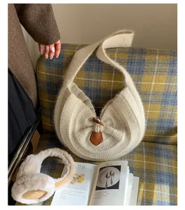 Close-up of knit texture on creamy beige tote bag featuring a vintage toggle button closure