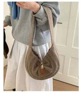 Detail view of brown knit shoulder bag showing wool texture and toggle horn button closure