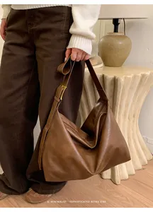 Dettaglio di una borsa tote retrò marrone con tracolla regolabile e fibbia dorata