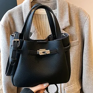 Vintage black lychee grain leather mini bucket bag with metallic buckle and shoulder strap