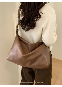 Borsa a spalla marrone capiente in pelle dallo stile retrò minimalista indossata