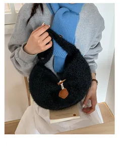 Detail of black faux fur crescent bag with decorative brown toggle horn button