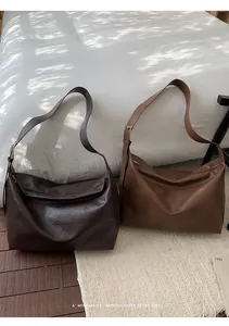 Dettaglio delle borse tote in pelle vintage con tracolle e fibbie dorate lucide