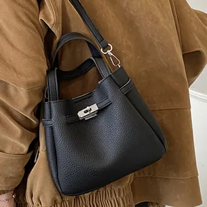 Chic black pebble leather bucket bag with silver twist lock and adjustable strap