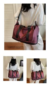 Detalle del bolso de viaje granate con correa ajustable y compartimento de zapatos