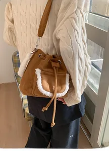 Detail of brown suede bucket bag with shearling trim and drawstring closure