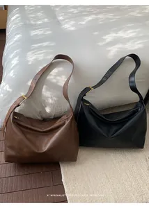 Dettaglio di grandi borse hobo retrò minimaliste in ecopelle marrone scuro e nero