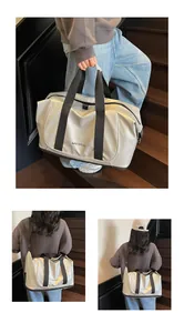 Detalle del bolso tote plateado metalizado con correas negras y bandolera