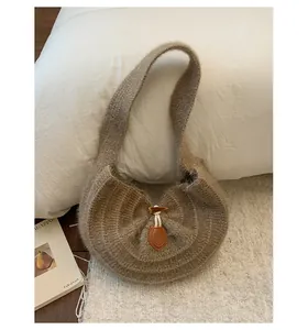 Detail of plush knitted shoulder bag with wooden toggle closure and leather accent