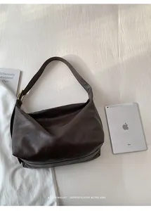 Dettaglio della grande borsa tote retrò marrone scuro con trama in pelle e fibbia dorata