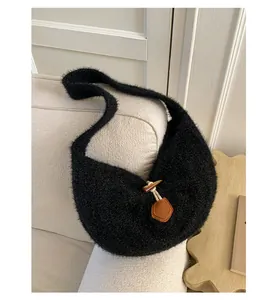 Detail of minimalist black knit shoulder bag featuring vintage toggle horn button closure