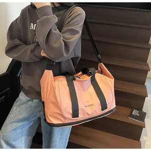 Detalle del bolso de viaje rosa con compartimento para zapatos y correa de bandolera