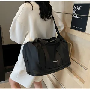 Detalle de un bolso grande negro con compartimento inferior para zapatos o ropa sucia