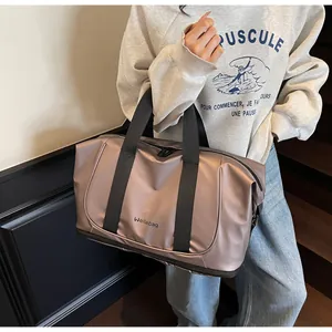 Detalle del bolso tote grande rosa metalizado llevado por modelo para referencia de tamaño