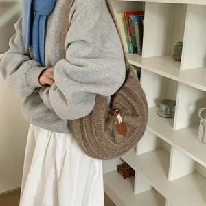 Coffee brown knitted hobo bag with vertical stripes and drawstring leather closure