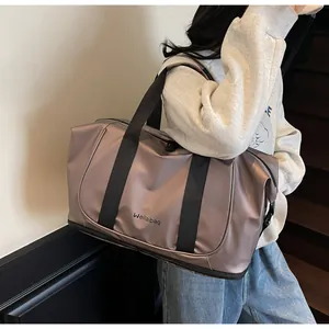 Detalle del bolso tote champán metalizado con correas laterales y logo de la marca
