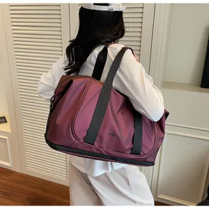Detalle de bolsa de viaje burdeos de gran capacidad con compartimento para zapatos