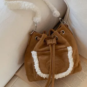 Brown faux suede bucket bag with white faux fur trim and drawstring closure