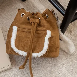 Brown suede bucket bag with shearling trim and drawstring for autumn winter style