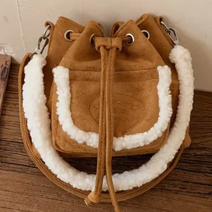 Brown faux suede bucket bag with white faux fur trim and adjustable shoulder strap
