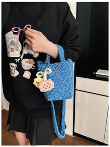 Detailaufnahme der blauen Plüschtasche mit Sternanhänger und kariertem Knopfdetail