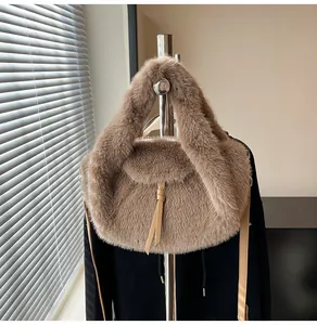 Gros plan du sac en fausse fourrure camel avec glands en cuir et support métallique